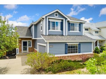Charming two-story home featuring blue siding, brick accents, and manicured landscaping at 3780 S Quemoy Way, Aurora, CO 80018