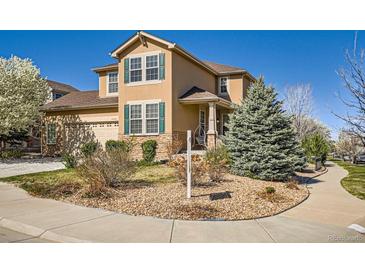 Two-story home featuring stucco and stone accents, a well-manicured yard, and a charming front porch at 20964 E Greenwood Pl, Aurora, CO 80013