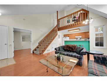 Cozy living room boasts hardwood floors, staircase, and open layout to the kitchen at 14110 E Dickinson Dr # A, Aurora, CO 80014