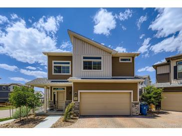 Beautiful two-story home with a modern design, landscaped front yard, and an attached two-car garage at 13589 E 102Nd Pl, Commerce City, CO 80022