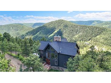 Stunning multi-story home nestled amongst the trees with mountain views at 14980 Elk Mountain Trl, Littleton, CO 80127