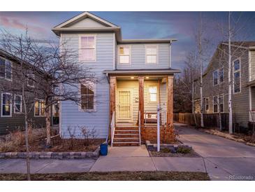 Charming two-story home featuring a welcoming front porch with wooden pillars and a well-maintained yard at 2550 Xanthia Ct, Denver, CO 80238