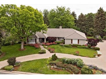 Landscaped front yard with circular driveway and mature trees framing the beautiful exterior of the home at 5340 S Logan Dr, Greenwood Village, CO 80121