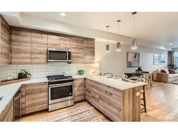 Modern kitchen featuring stainless steel appliances and a center island with barstool seating at 1810 Irving St # 4, Denver, CO 80204