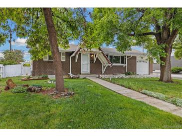 Charming brick home featuring a well-manicured lawn and inviting walkway to the front door at 8137 Vanguard Dr, Denver, CO 80221