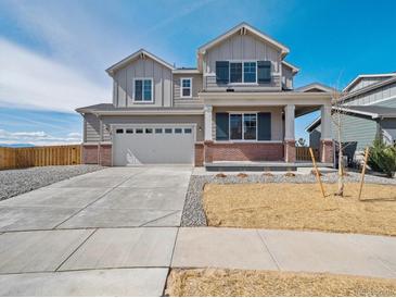 Charming two-story home with a covered front porch, a two-car garage, and professionally landscaped front yard at 10145 Quentin Ct, Commerce City, CO 80022