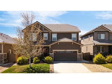 Beautiful two-story home boasts manicured lawn and a two-car garage, with stone accents on the facade at 12563 Grape St, Thornton, CO 80241