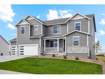 Charming two-story home with gray siding, stone accents, manicured lawn, and an attached two car garage at 5439 Westin Hills Dr, Elizabeth, CO 80107