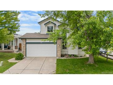 Charming two-story home featuring a spacious two car garage and manicured front lawn at 8544 S Upham Way, Littleton, CO 80128