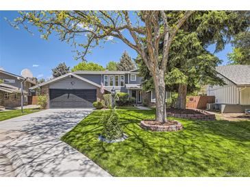 Charming two-story home with a well-manicured lawn, mature trees, and a two-car garage at 6338 S Oneida Ct, Centennial, CO 80111