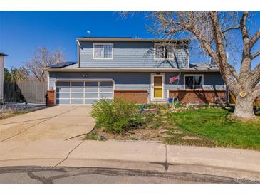 Charming two-story home featuring a well-maintained front yard, attached garage, and sunny yellow front door at 4465 E 121St Pl, Thornton, CO 80241
