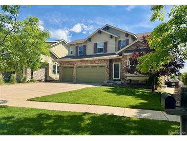 Inviting two-story home featuring a well-manicured lawn and a convenient two-car garage at 24714 E Quarto Pl, Aurora, CO 80016