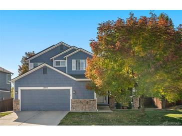 Charming blue two-story home with stone accents, mature landscaping, and an attached two-car garage at 1540 Meachum Way, Erie, CO 80516