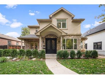 Stunning two-story home featuring a stone and stucco facade, manicured landscaping, and a welcoming entrance at 1214 S Fillmore St, Denver, CO 80210