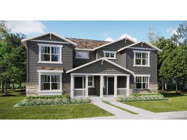 Two-story home with gray siding, front porch, and landscaping at 15261 Fillmore St, Thornton, CO 80602