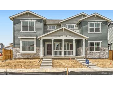 Charming new construction home featuring a covered porch and a mix of stone and siding details at 15261 Fillmore St, Thornton, CO 80602