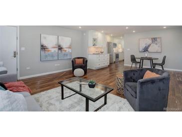 Inviting living room featuring hardwood floors, modern furnishings, and an open floor plan with eat-in kitchen at 909 N Logan St # 1B, Denver, CO 80203