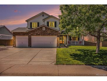 Charming two-story home featuring a stone-accented facade, a well-manicured lawn, and a spacious three-car garage at 1325 Kingsfield St, Castle Rock, CO 80104