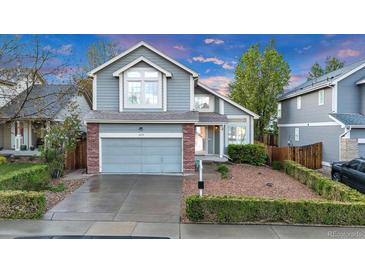 Charming two-story home featuring a manicured lawn, brick accents, and an attached two-car garage at 4279 Brandon Ave, Broomfield, CO 80020