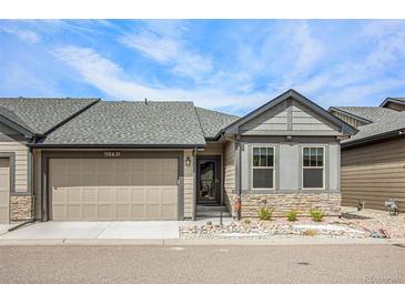 Charming home featuring stone accents, a well-kept lawn, and an attached two-car garage at 11791 Barrentine Loop, Parker, CO 80138