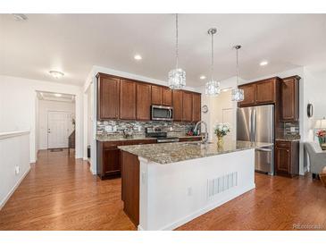 Modern kitchen with stainless steel appliances, granite countertops, and a large island at 11791 Barrentine Loop, Parker, CO 80138