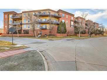 Condominium complex featuring brick and painted siding with private balconies and beautiful architectural details at 15475 Andrews Dr # 318, Denver, CO 80239