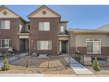 Charming townhome showcasing a well-maintained brick facade, stylish gray accents, and neat landscaping at 6634 S Patsburg St, Aurora, CO 80016