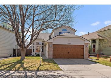 Charming two-story home with a well-maintained lawn, mature tree, and a two-car garage at 11570 Depew Ct, Westminster, CO 80020