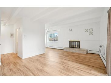 Bright living room features hardwood floors, a decorative fireplace, and large windows with city views at 250 N Pearl St # 310, Denver, CO 80203