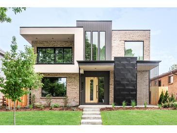 Modern home featuring mixed brick and panel facade with a well-manicured lawn and minimalist landscaping at 1466 S Gaylord St, Denver, CO 80210