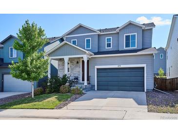 Charming two-story home with a well-manicured lawn, covered porch, and a two car garage at 1173 Basalt Ridge Loop, Castle Rock, CO 80108
