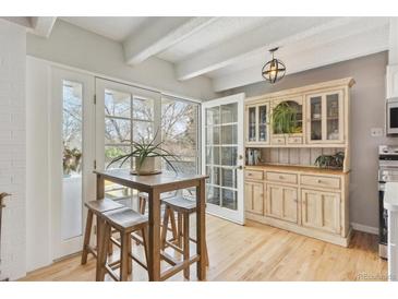 Bright kitchen features a breakfast nook with light wood floors, white ceiling beams, and a built-in hutch at 33 N Corona St # 401, Denver, CO 80218