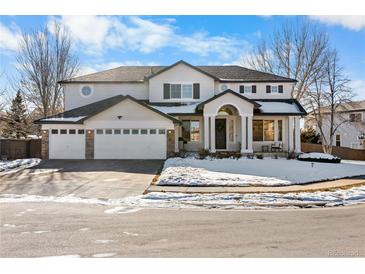 Two-story home with three-car garage and landscaped front yard at 806 Ridgemont Cir, Highlands Ranch, CO 80126