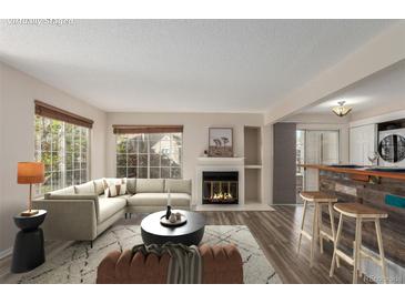 Cozy living room with a fireplace, comfortable seating, and natural light at 13792 E Lehigh Ave # E, Aurora, CO 80014