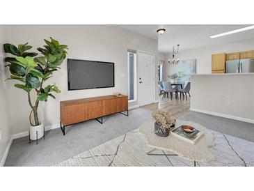 Stylish living room with a modern TV console, elegant decor, and views into the dining area at 1050 Opal St # 102, Broomfield, CO 80020