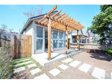 Cozy backyard patio with modern pergola, stylish glass doors, and charming stone walkway at 3735 Inca St, Denver, CO 80211