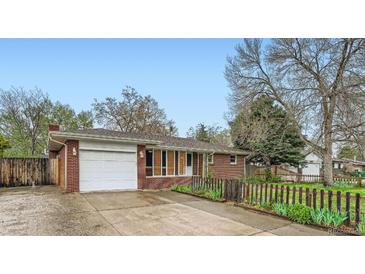 Charming single-story brick home featuring a well-maintained lawn, attached garage, and inviting curb appeal at 1740 S Estes St, Lakewood, CO 80232