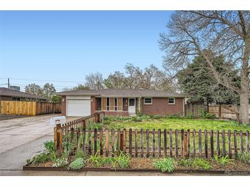 Charming brick home with well-manicured front yard, a cute fence, and inviting curb appeal at 1740 S Estes St, Lakewood, CO 80232
