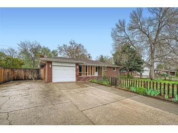 Charming single-story brick home with a well-maintained front yard, driveway, and attached garage at 1740 S Estes St, Lakewood, CO 80232
