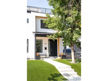 Modern two-story home boasting a manicured lawn, stylish black door, and a minimalist aesthetic at 2321 S Acoma St, Denver, CO 80223