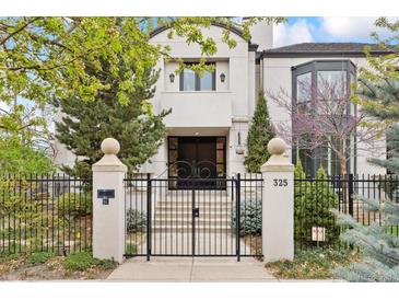 Elegant home featuring a gated front entrance with decorative columns and manicured landscaping at 325 Clayton St, Denver, CO 80206