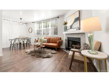 Bright living room featuring a fireplace, wood floors, and comfortable seating at 5745 W Atlantic Pl # 108, Lakewood, CO 80227