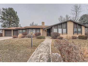 Charming single-story home with a brick exterior, mature landscaping, and a welcoming walkway at 9451 E Evans Pl, Denver, CO 80231