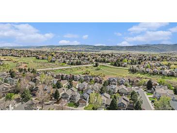 Expansive aerial view of the residential neighborhood with tree lined streets and mountain views at 9921 Spring Hill Pl, Highlands Ranch, CO 80129
