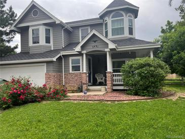 Charming two-story home with a landscaped yard and blooming red roses at 5491 S Youngfield W Ct, Littleton, CO 80127