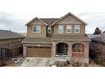 Inviting two-story home featuring brick accents, an attached garage, and a covered porch at 239 N Irvington St, Aurora, CO 80018