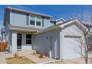 Charming two-story home featuring light blue siding and attached garage and manicured lawn at 11141 Gaylord St, Northglenn, CO 80233