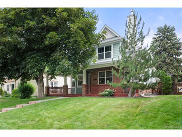 Charming two-story home featuring a well-maintained lawn, mature trees, and a welcoming front porch at 1544 S Elizabeth St, Denver, CO 80210