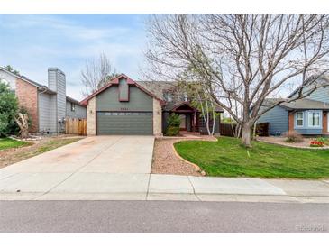 Charming home featuring a spacious front yard with mature trees and a two-car garage at 5421 S Vivian St, Littleton, CO 80127
