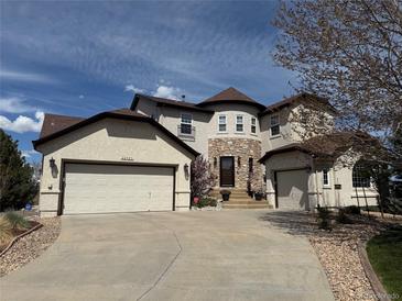 Stunning stucco and stone two-story home with a three-car garage and circular driveway at 22485 Laurel Oak Dr, Parker, CO 80138